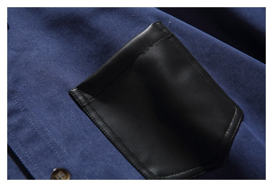 Close-up of the shirt’s black stitched chest pocket against navy fabric.