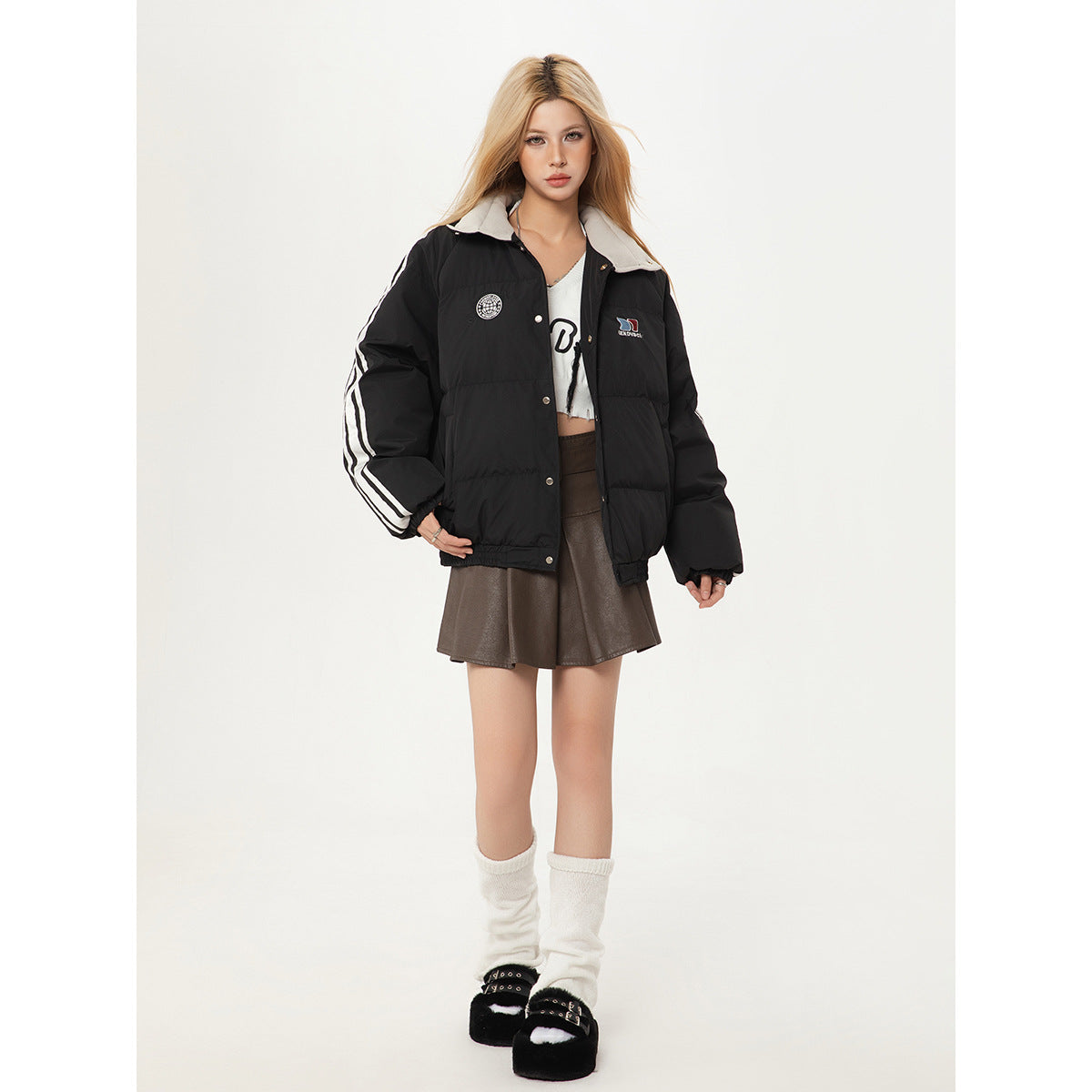 Front view of a model wearing a black padded jacket with white sleeve stripes and a light collar.