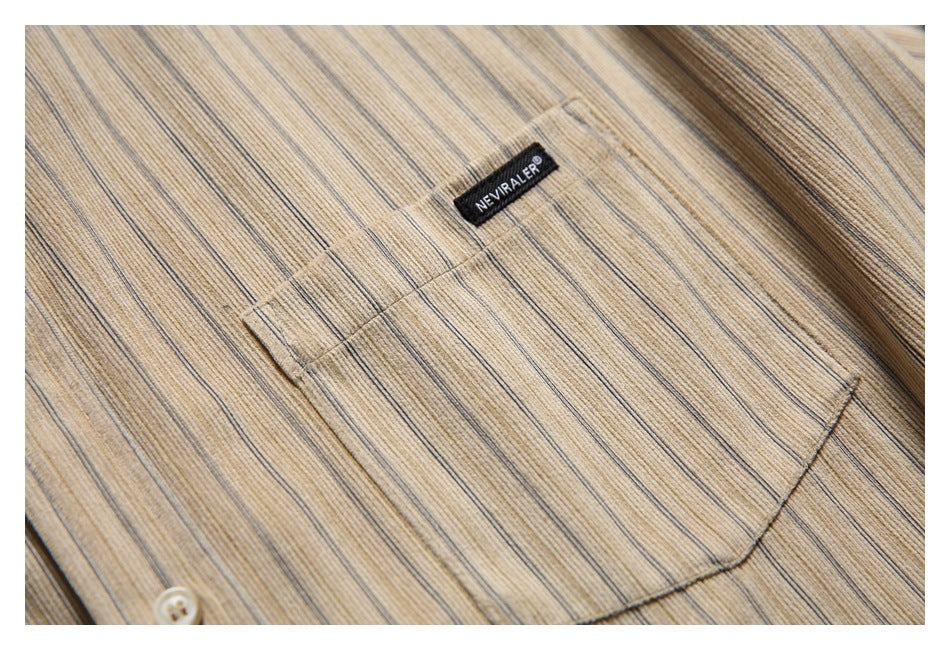 Close-up of a chest pocket and small woven brand label on a beige vertically striped shirt.