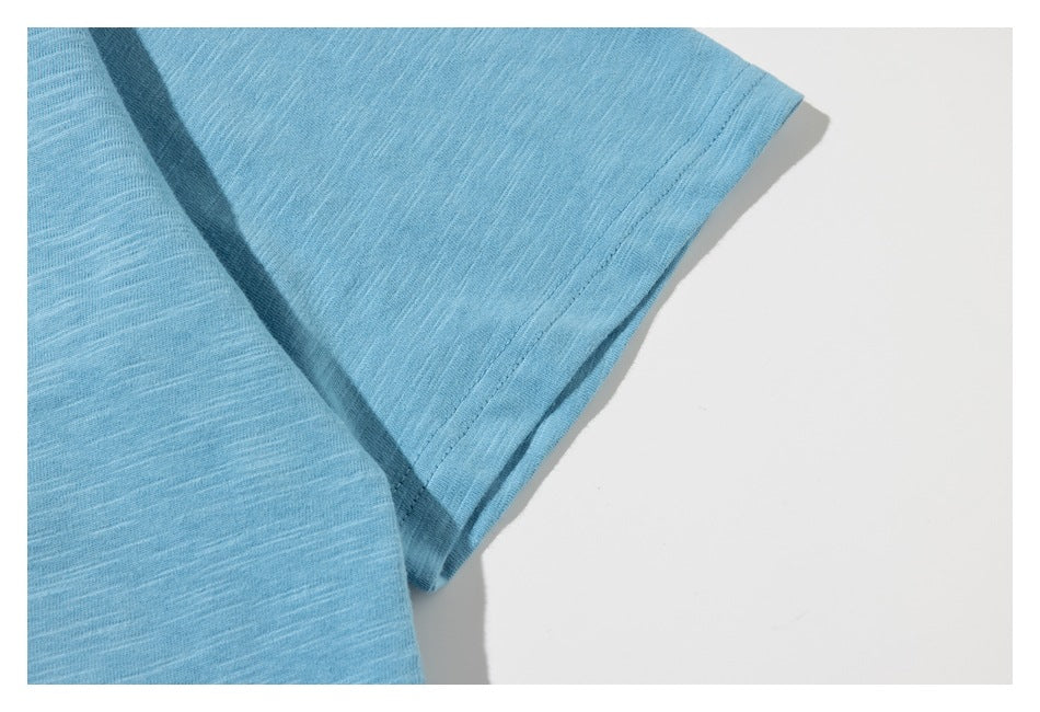 Close-up of the light blue shirt’s short sleeve and stitched sleeve hem.