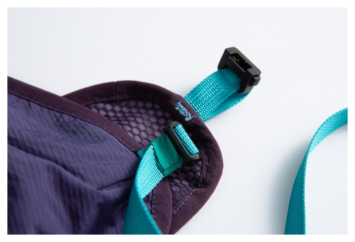 Close-up of a backpack corner with turquoise adjustment straps, black hardware, and purple mesh and fabric panels.