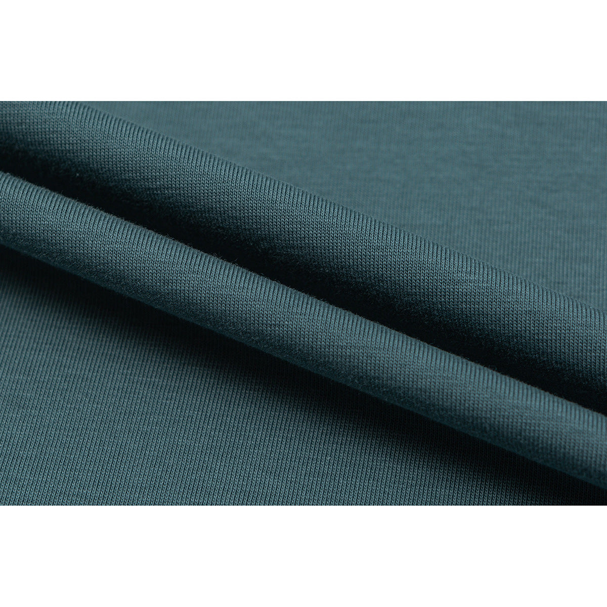 Close-up of teal knit fabric folded to show its texture and drape.
