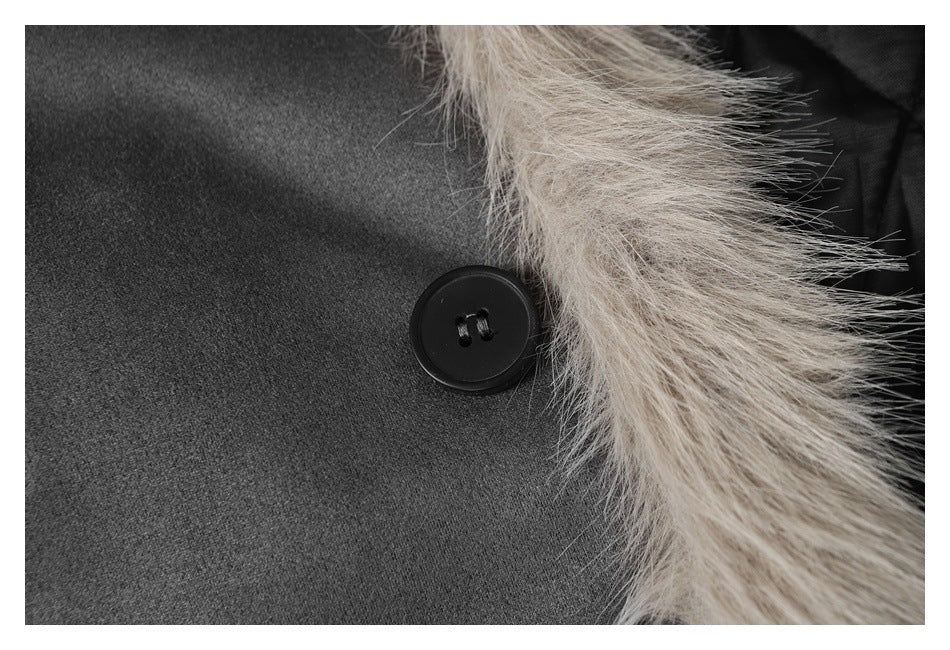 Close-up of a black button beside the pale beige fur trim on charcoal jacket fabric.