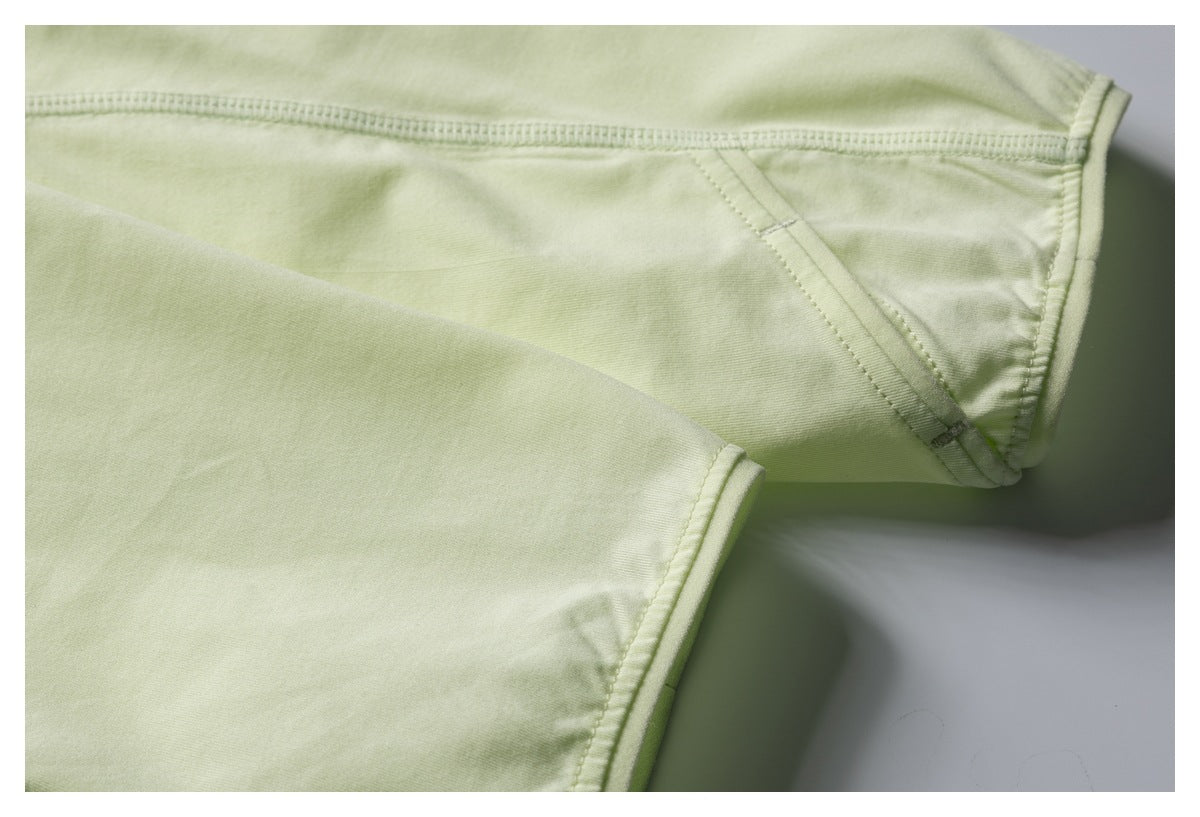 Close-up of pale lime garment seams and finished edges.