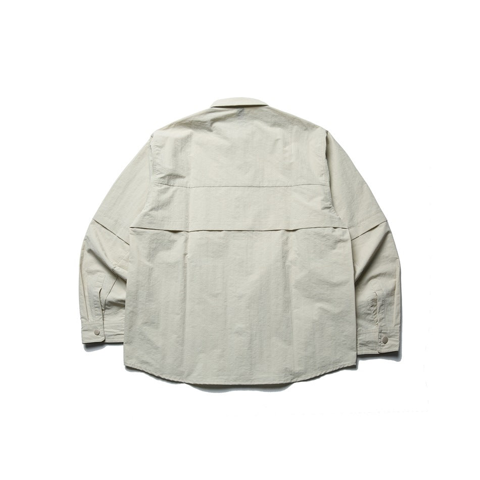 Back view of a light beige long-sleeve shirt with a pointed collar, button cuffs, and a horizontal back yoke.