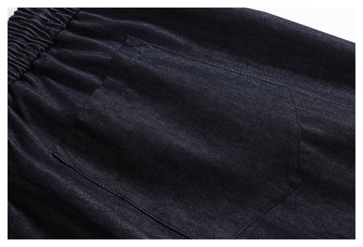 Close-up of a large patch pocket on dark indigo trousers.