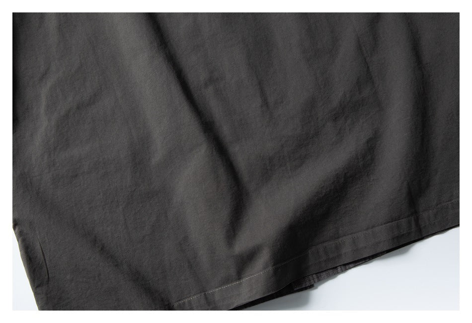 Close-up of dark charcoal garment fabric with a stitched hem.
