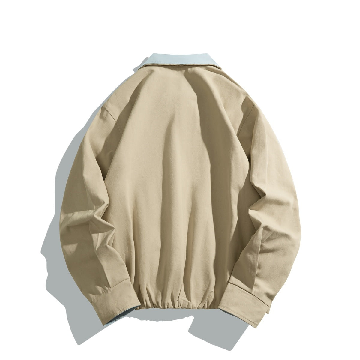 Back view of a beige jacket with a pale blue collar and gathered hem.