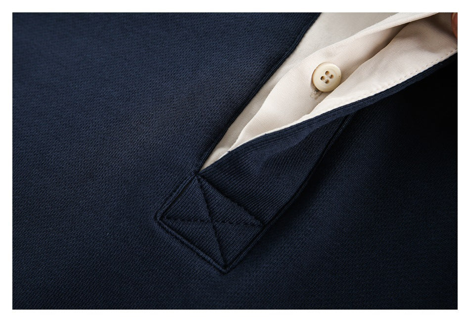 Close-up of the cream button and inner placket against the navy sweatshirt fabric.