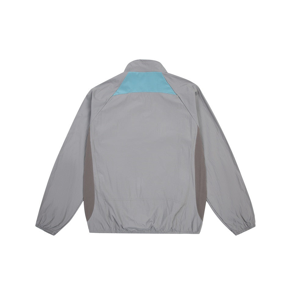 Back view of a gray long-sleeve jacket with a turquoise upper-back panel and dark gray side panels.