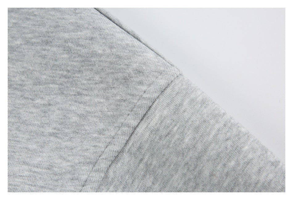 Close-up of a heather gray sweatshirt shoulder seam and sleeve.