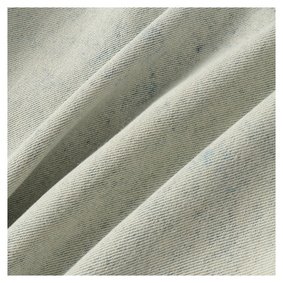 Close-up of the diagonal weave and subtle blue markings on light-wash denim.