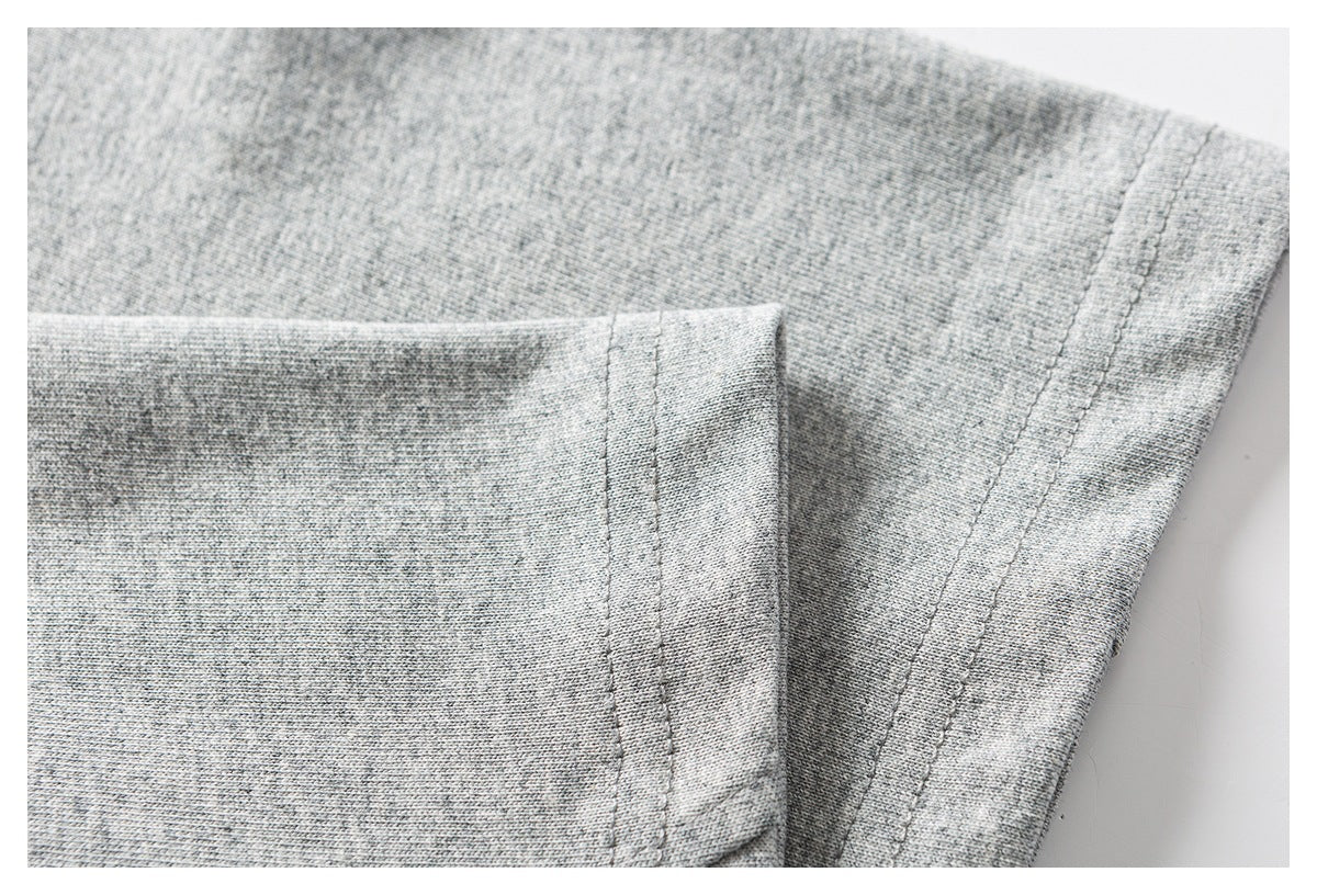Close-up of heather gray knit fabric and a stitched garment seam.