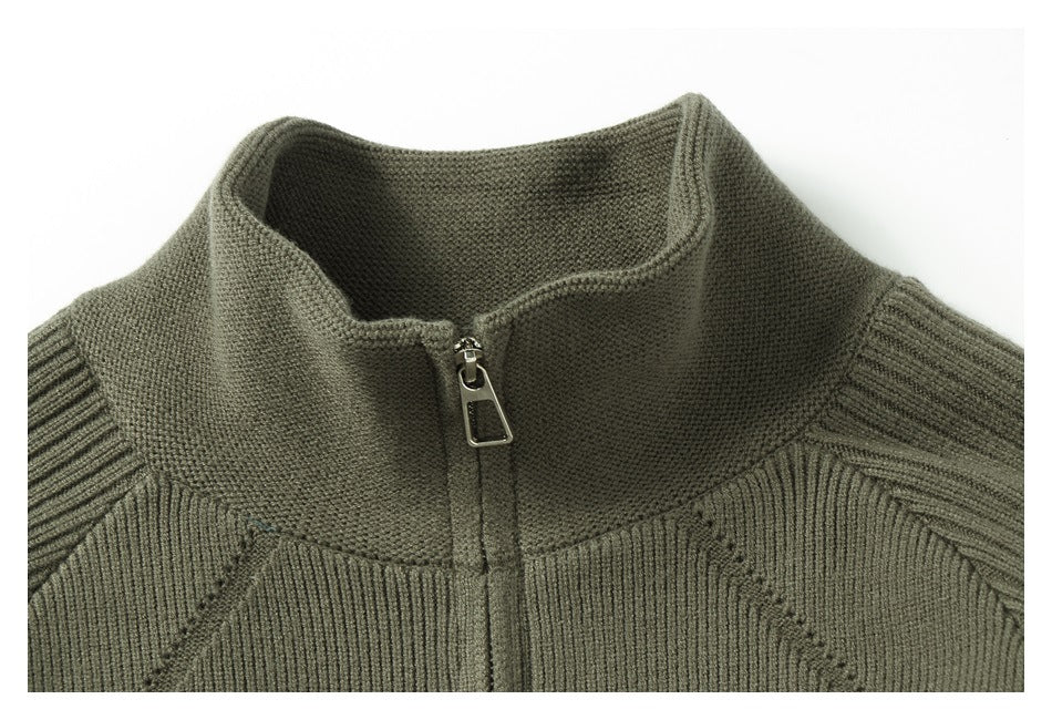 Close-up of the olive knit jacket's stand collar, front zipper, and ribbed shoulder stitching.