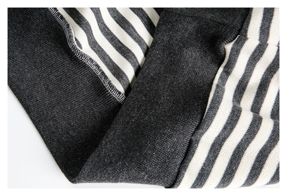 Close-up of a charcoal ribbed cuff and stitched seam beside cream and charcoal stripes.