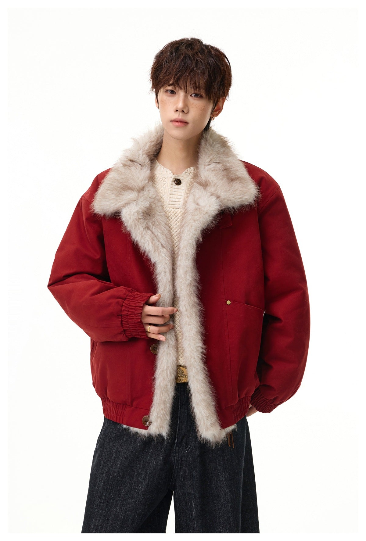 Model wearing a deep red jacket with a large light beige fur-trimmed collar and front over a cream knit top.