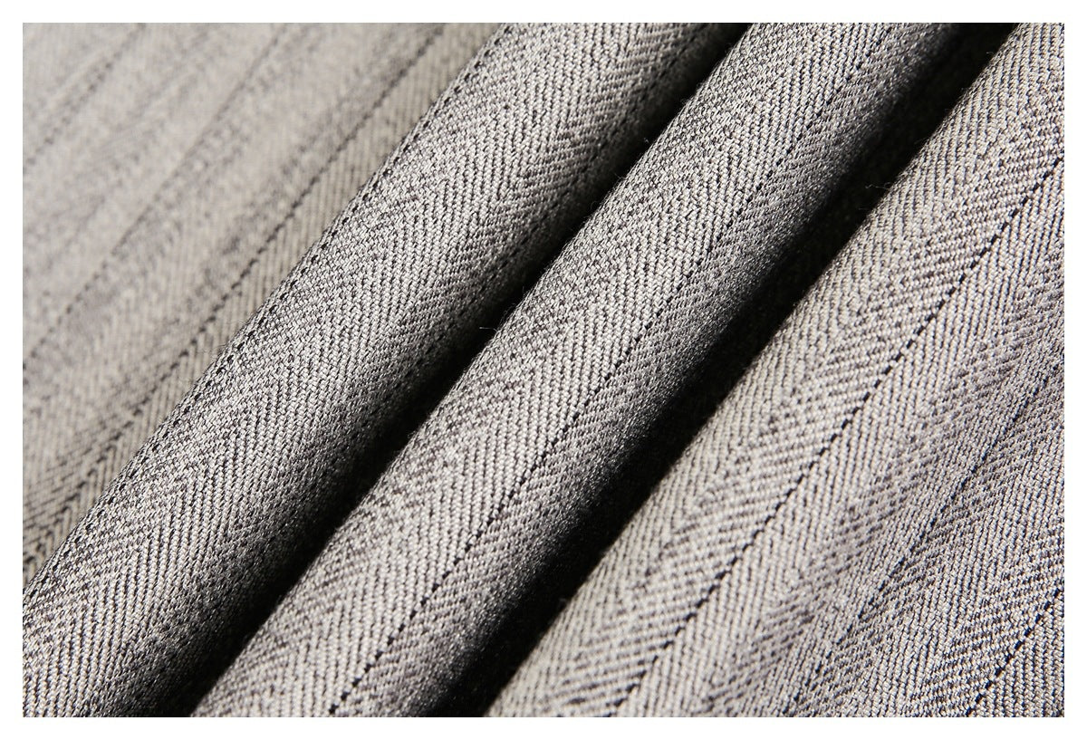 Macro view of the gray-beige fabric's diagonal woven pattern and folded ridges.