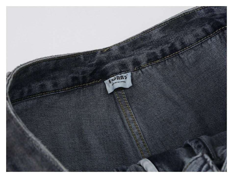 Close-up of the inside waistband and stitched brand label on dark washed jeans.