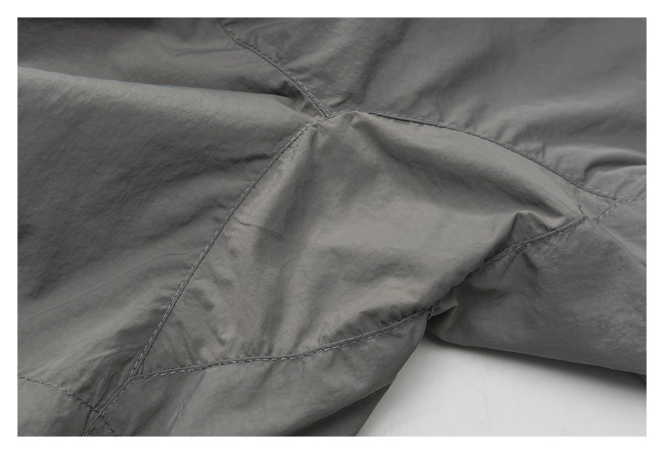 Close-up of gray shorts showing intersecting panel seams and stitching.