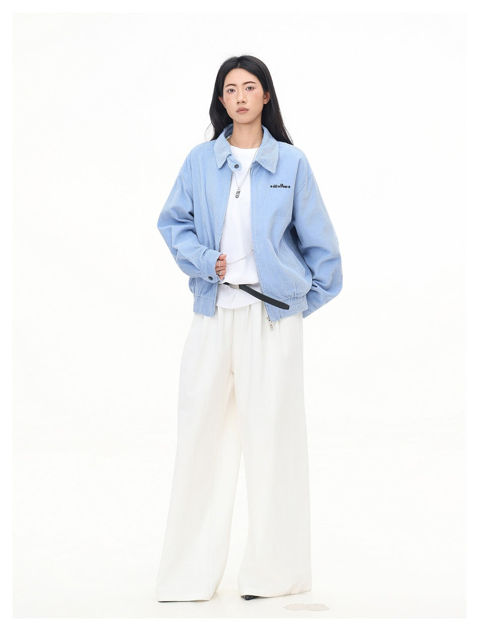 Full-length view of a model in a light blue corduroy jacket, white tee and white wide-leg trousers