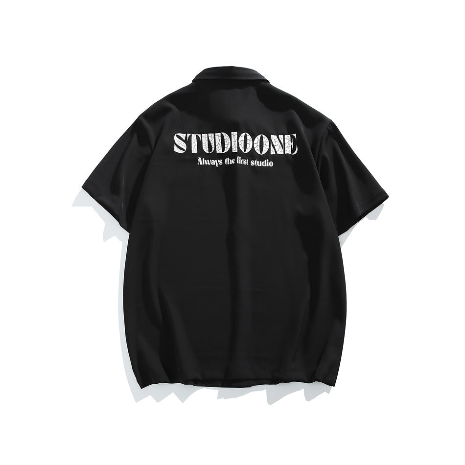 Back view of black short-sleeve shirt with large white STUDIOONE graphic print across the upper back