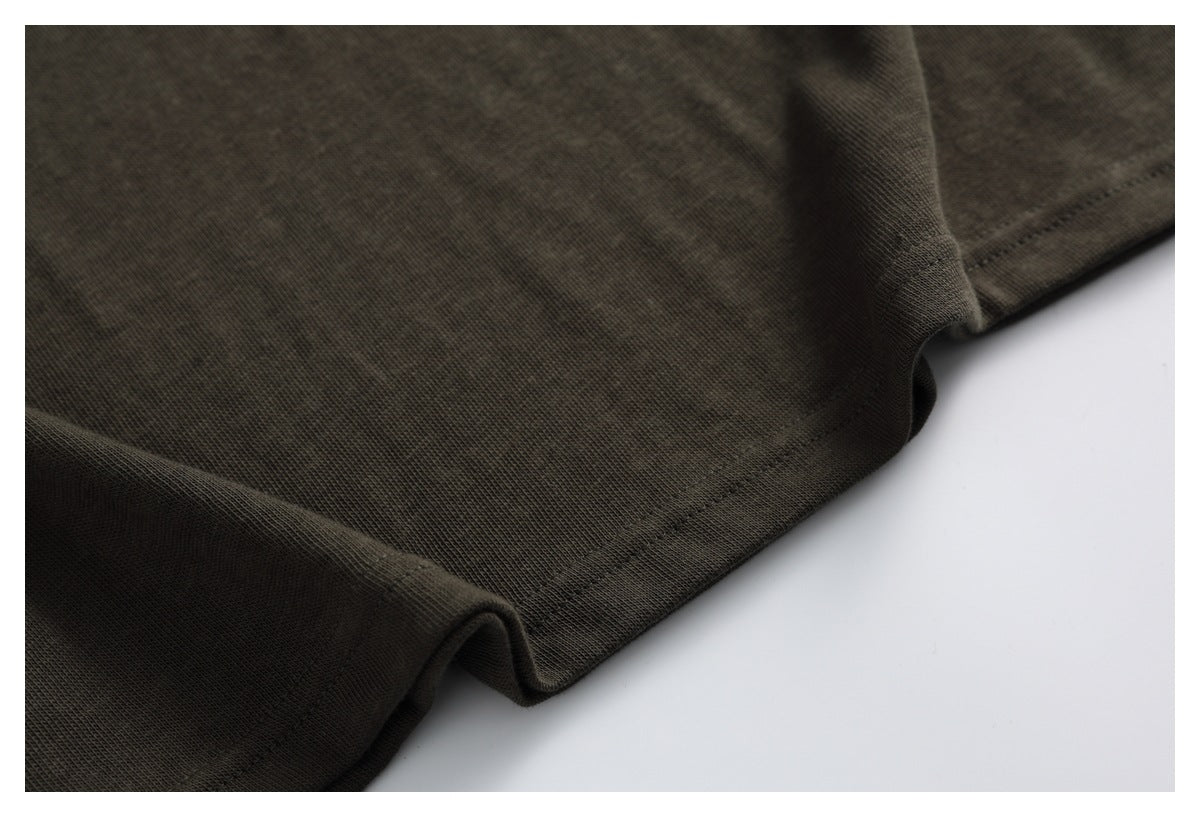 Close-up of the dark olive-brown T-shirt's double-stitched bottom hem.