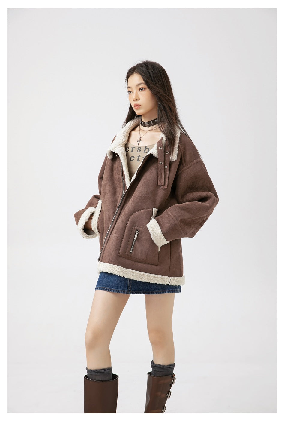 Model in a three-quarter view of the brown jacket with cream fleece trim, collar strap and zip pocket