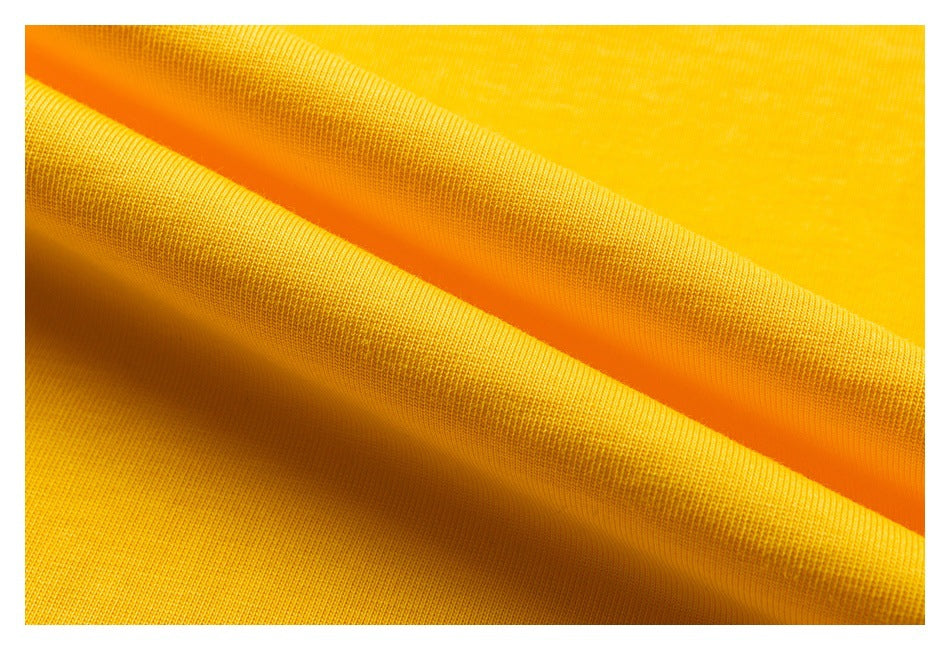 Close-up of bright yellow fabric draped in soft folds, showing its fine knit texture.