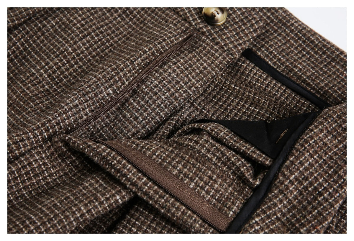 Close-up of brown check fabric showing a diagonal zipper pocket, dark lining, and a tan button.