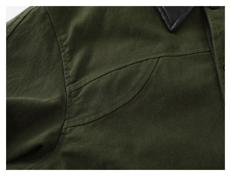 Close-up of the olive jacket's curved chest pocket seam and part of its black collar.