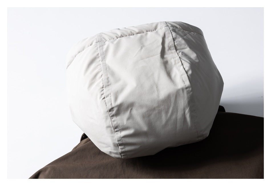 Close-up of the light gray hood exterior resting against the dark brown jacket.