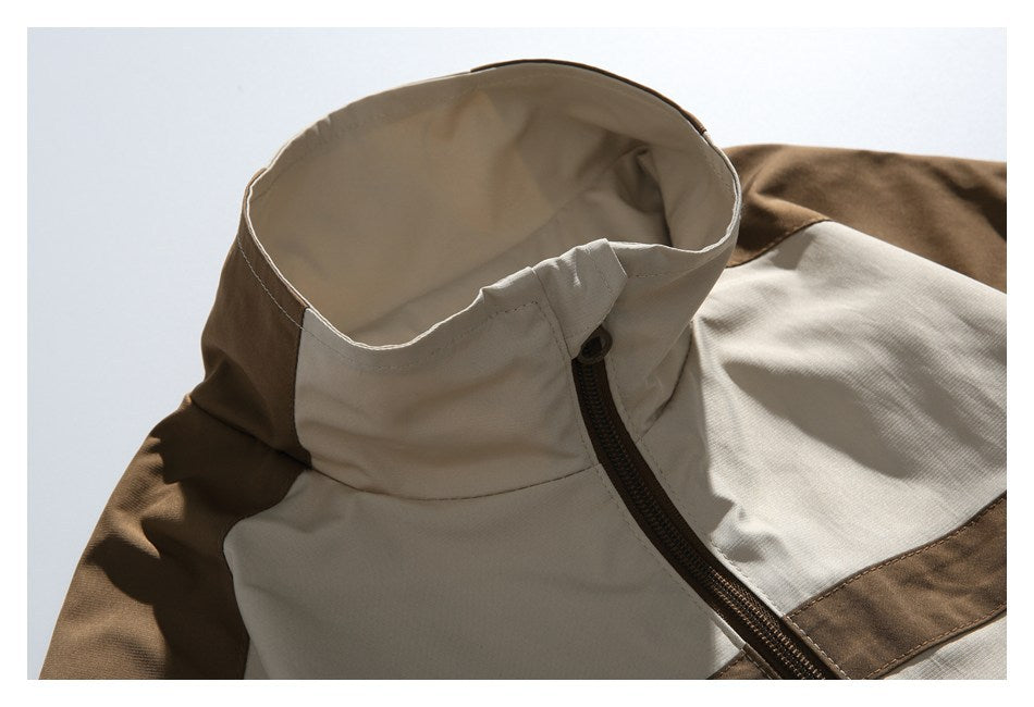 Close-up of a cream and brown color-block jacket collar, shoulder panels, and front zipper.