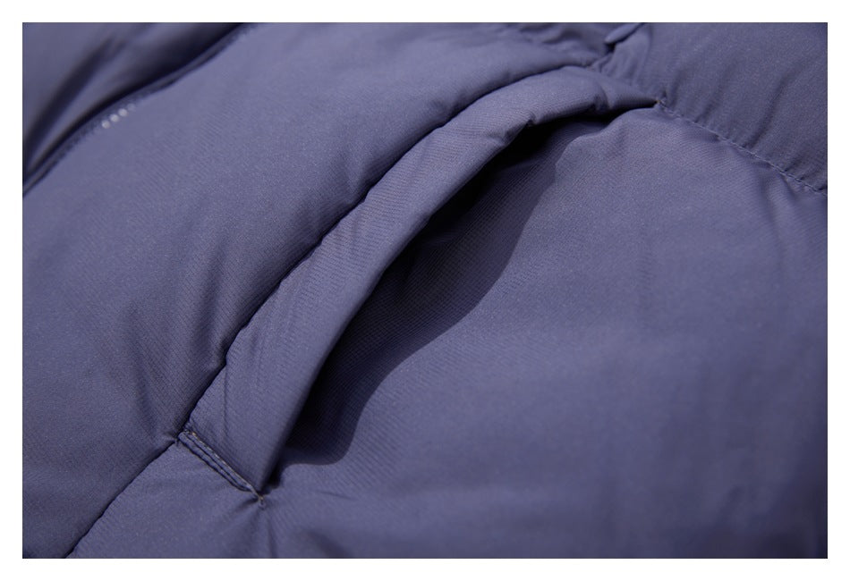 Close-up of a curved pocket opening on a slate-blue padded garment.