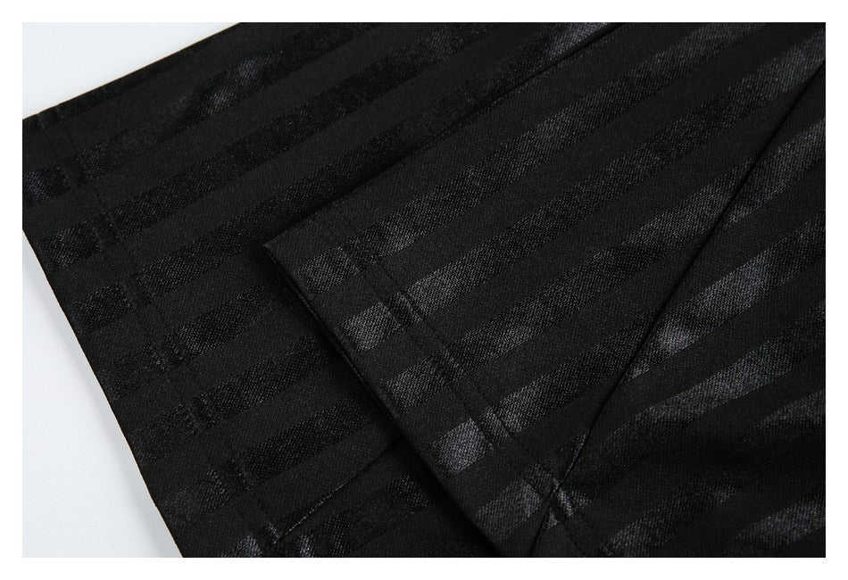 Close-up of black striped fabric with overlapping panels and visible stitching.