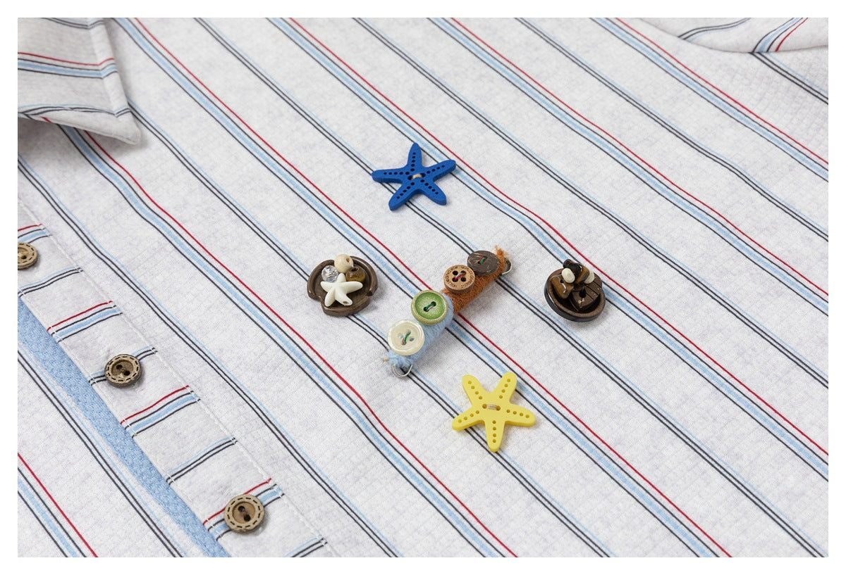 Close-up of a light gray striped shirt placket with brown buttons and decorative starfish-shaped buttons.