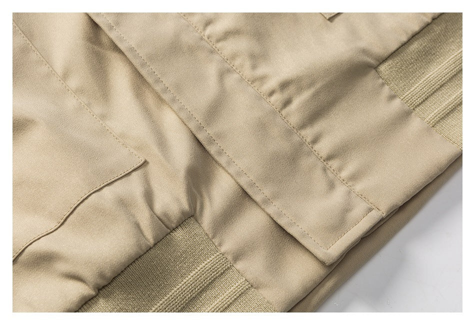 Close-up of a beige jacket hem with stitched panels and rib-knit trim.