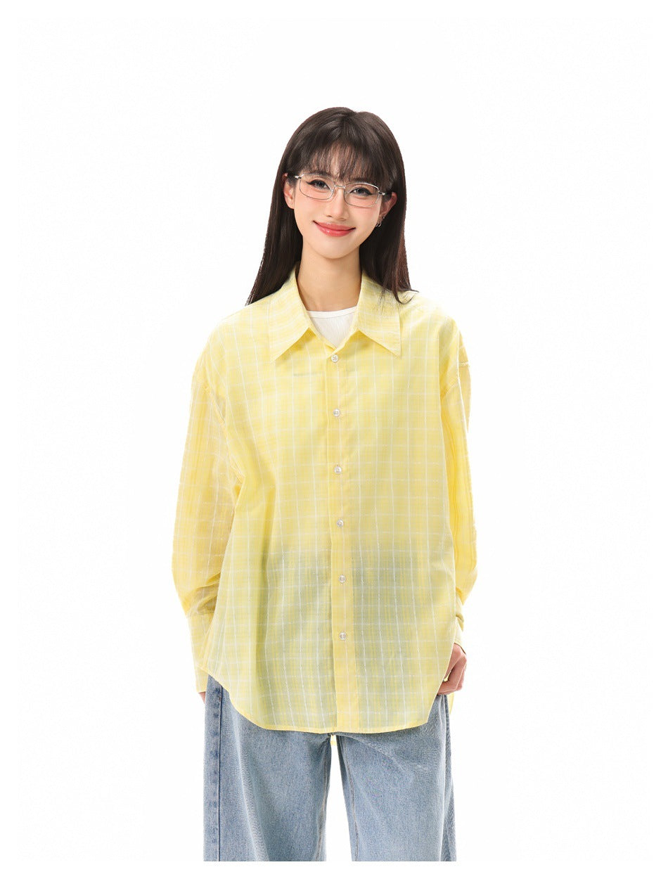 Front view of a model wearing an oversized yellow windowpane-check button-up shirt over a white top and blue jeans.