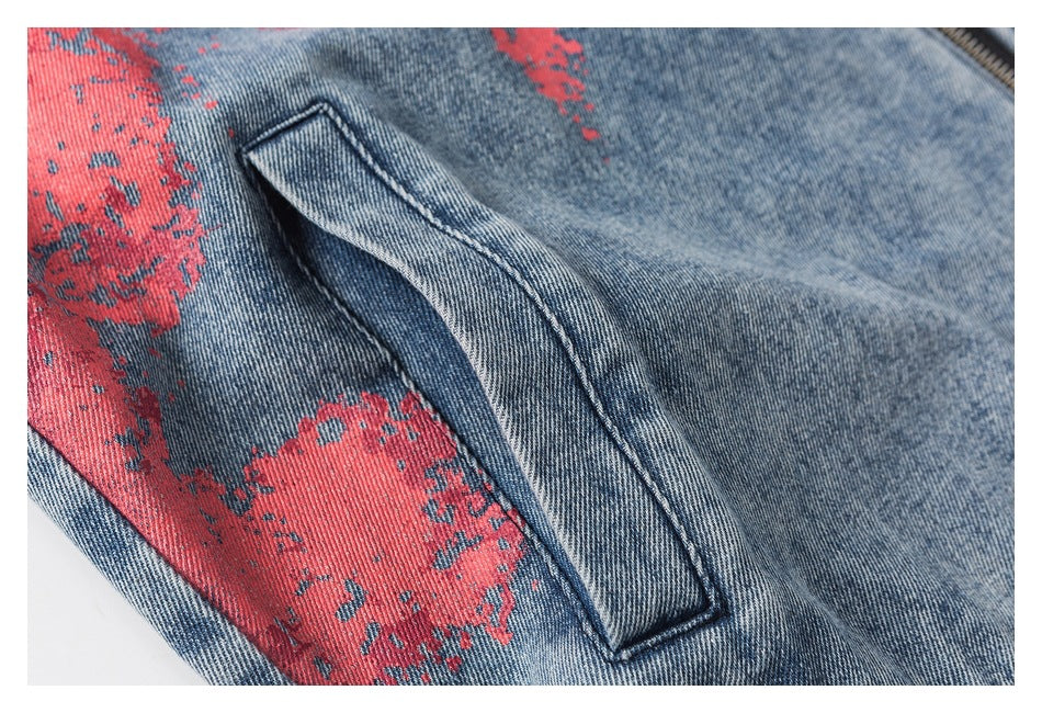 Close-up of a slanted pocket on blue denim with a distressed red print.