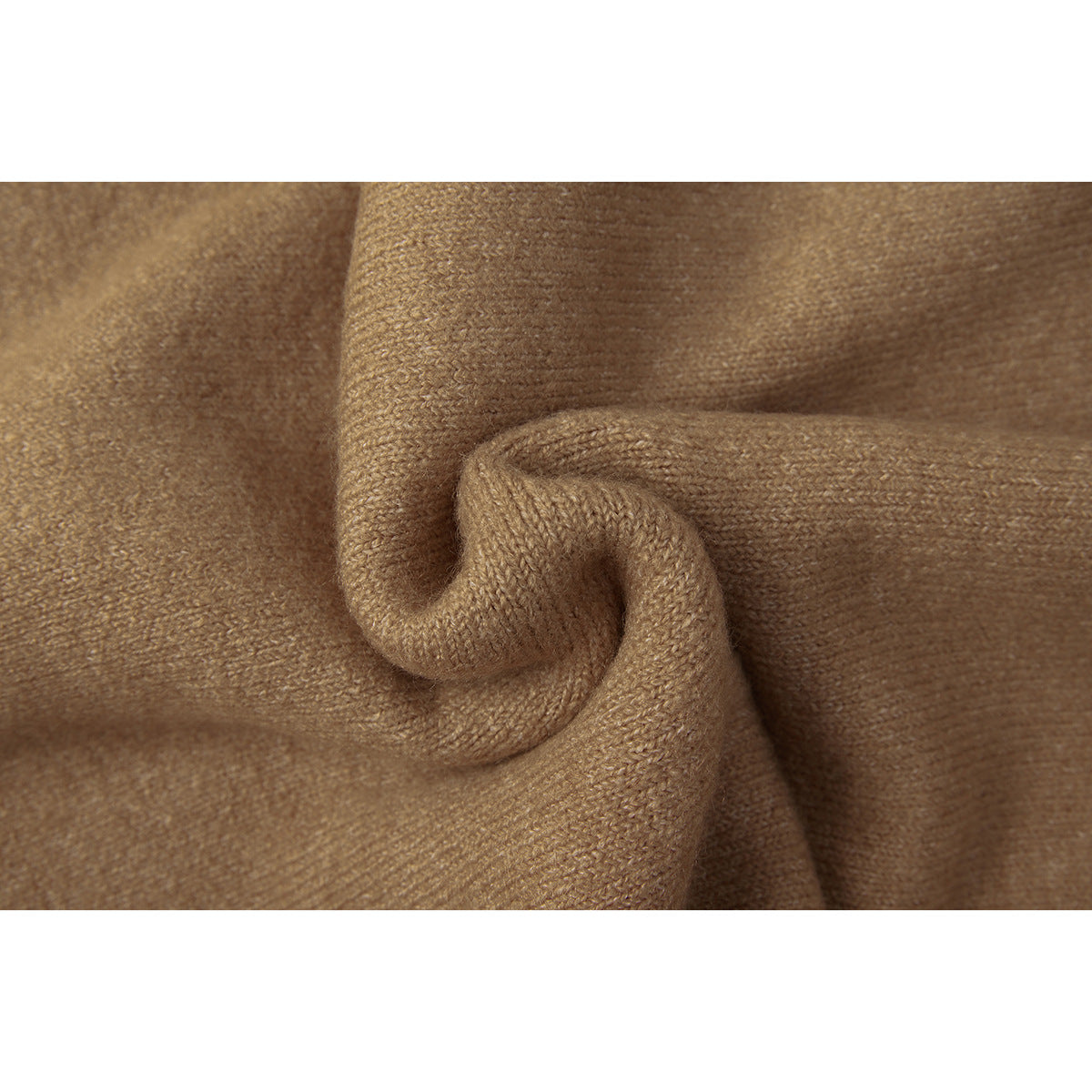 Extreme close-up of tan knit fabric folded to show its texture.