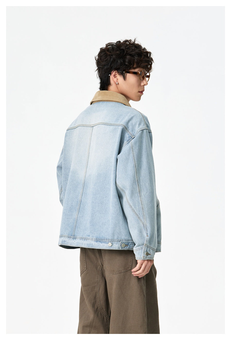 Model shown from behind in a light-wash denim jacket with a tan collar and adjustable button tabs at the hem.
