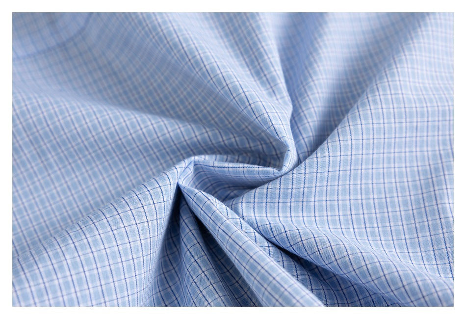 Close-up of light blue and white plaid fabric gathered into folds.