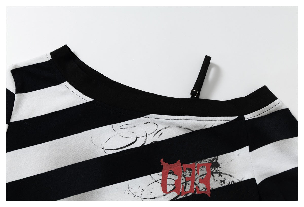 Upper portion of a black-and-white striped shirt showing its wide neckline, thin strap, and distressed chest graphic.