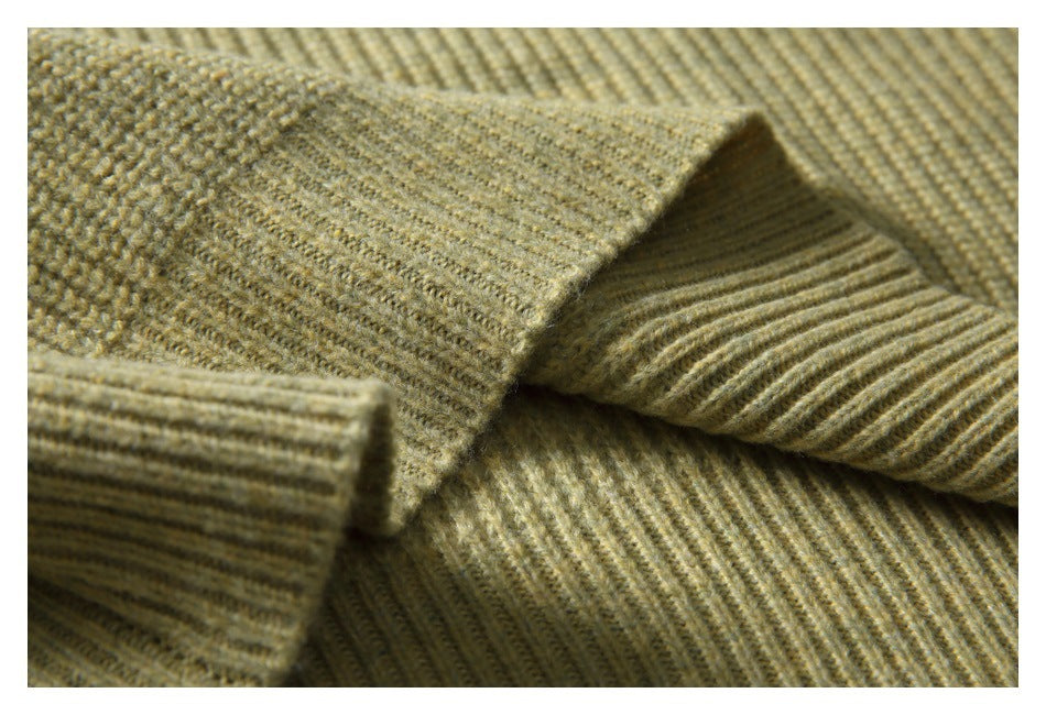Close-up of the olive-beige sweater's ribbed knit and folded sleeve cuff.