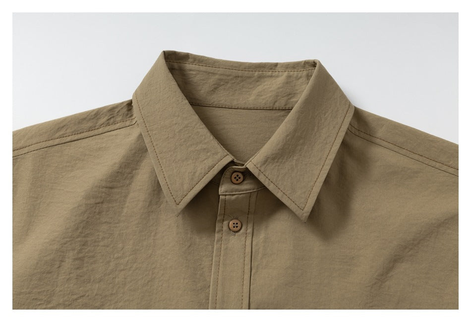 Close-up of the tan shirt's pointed collar and upper front with brown buttons.