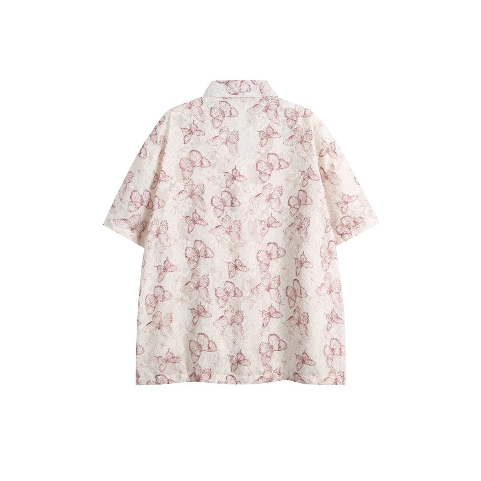 Back view of an ivory short-sleeve shirt covered in dusty rose butterfly and floral patterns.