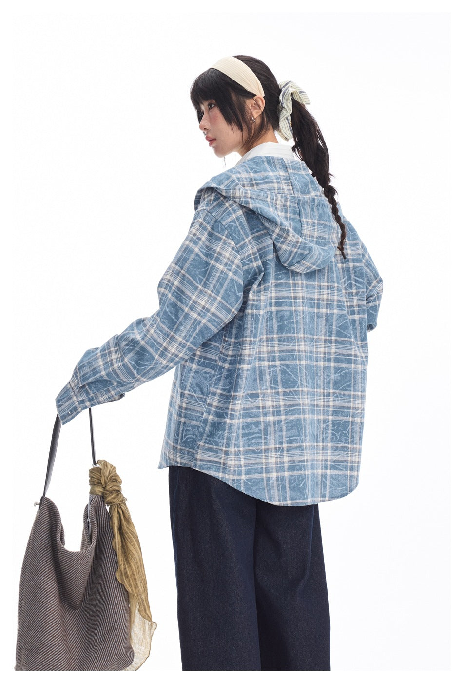 Back view of a model wearing a blue-and-white plaid hooded shirt jacket with a curved hem.