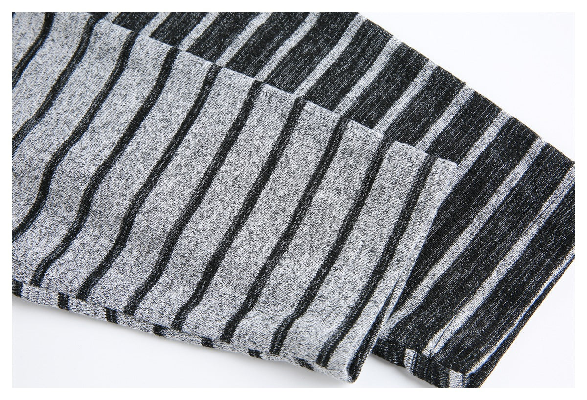 Close-up of gray knit fabric with narrow black stripes and a finished edge.