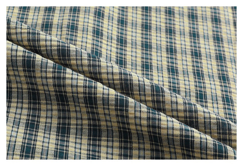 Close-up of the cream and dark plaid fabric folded to show its pattern and texture.