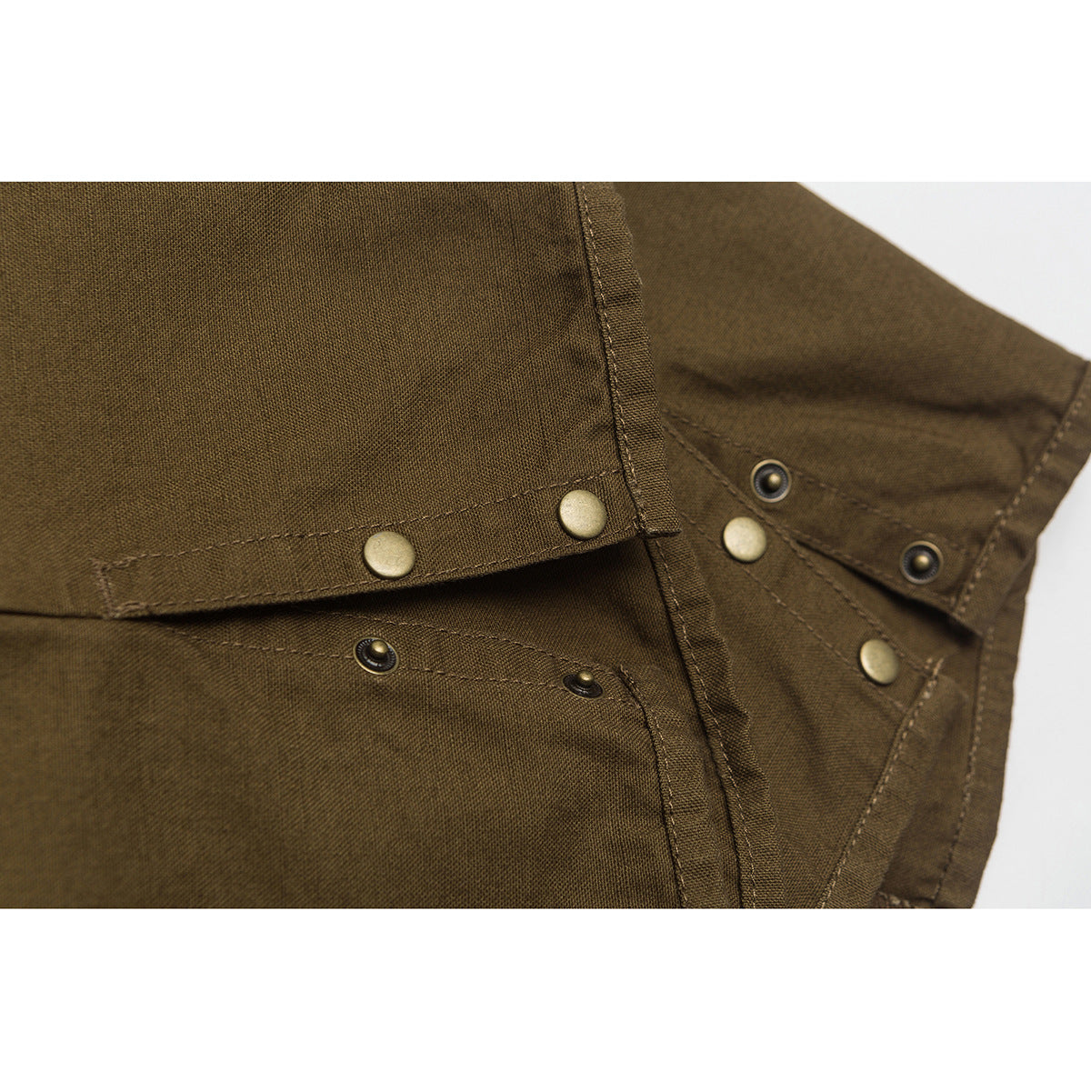 Close-up of brown pants with stitched seams and metal snaps.