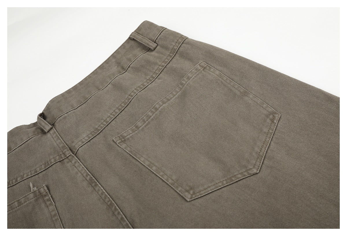 Close-up of a taupe-gray trouser back pocket, waistband, and belt loop with visible twill texture and stitching.